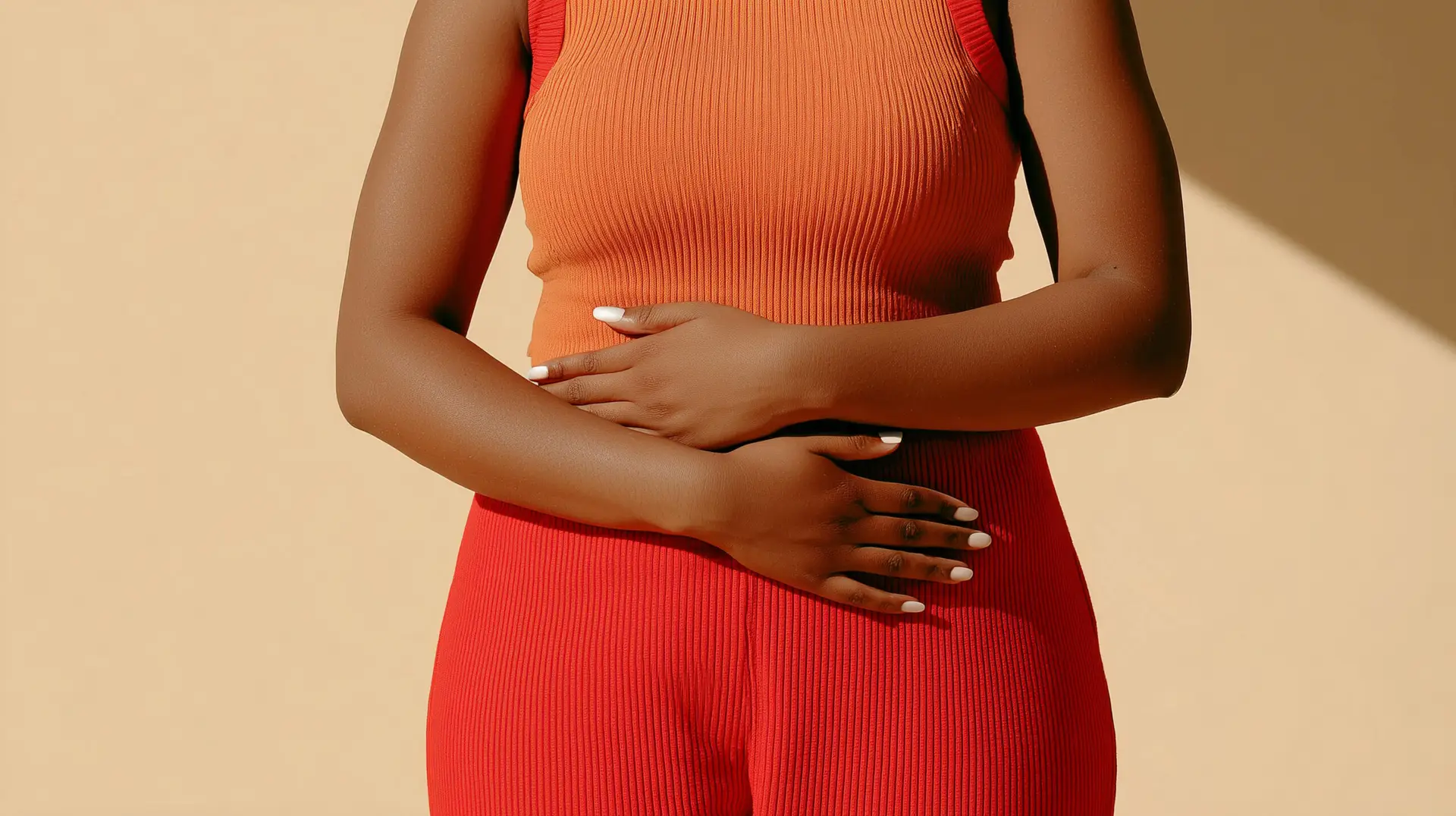 Personne tenant son ventre en tenue rouge et orange