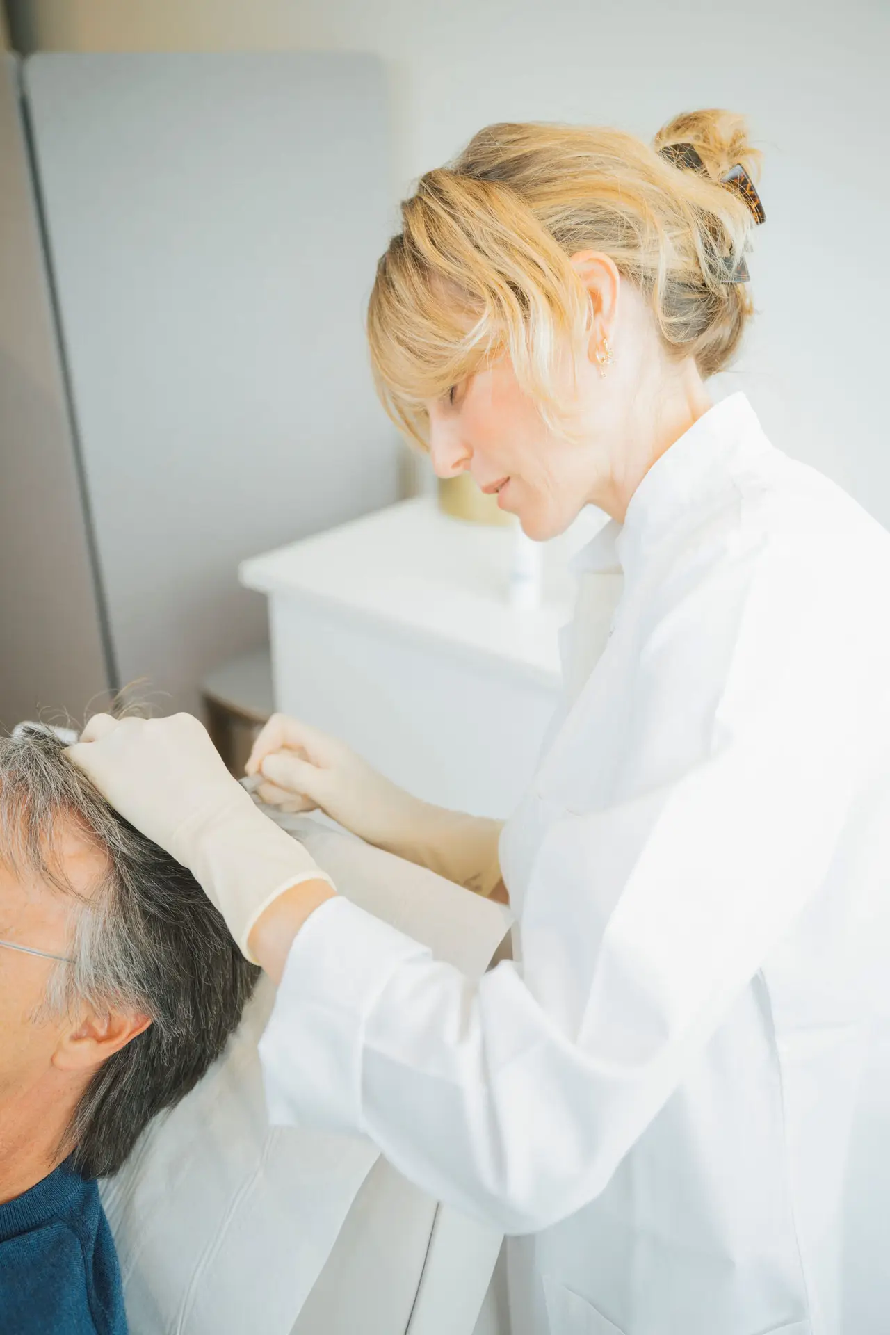 Docteur effectuant un traitement capillaire en clinique