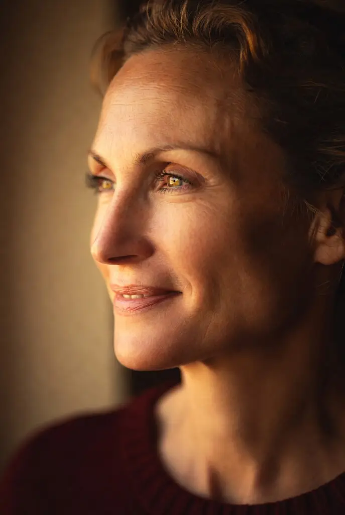 Femme souriante regardant la lumière du soleil